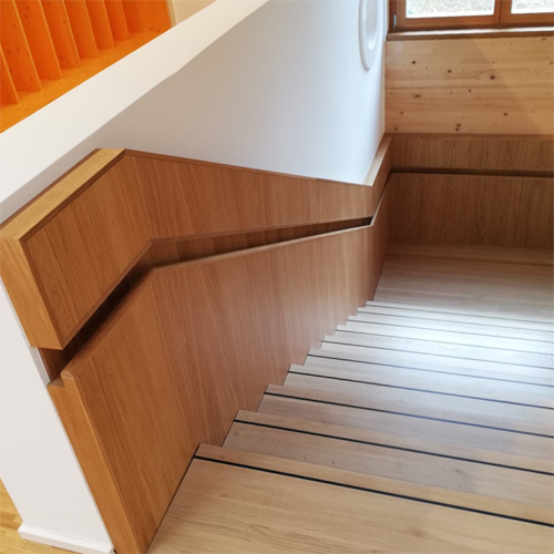 Holztreppe mit Treppenlauf und Antirutschschiene auf den Stufen