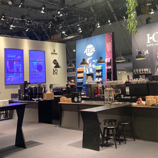 Messestand Kaffeewerkstatt 2024 Mit Theke Bewegung, Hockern , Bänken, Kaffeewerkstatt, Grafikwänden, Theke mit Fließen, Regalen und vielem mehr